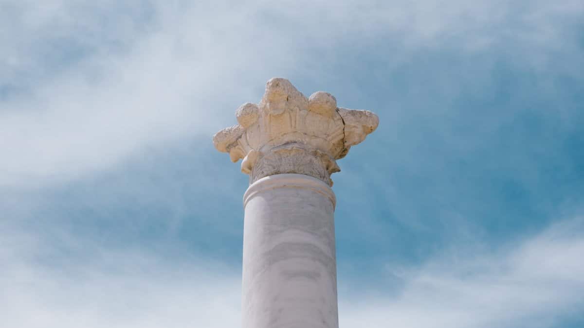 A stunning view of an ancient marble column under a clear blue sky in Side, Antalya, Türkiye.
