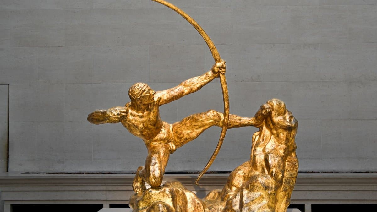 Golden archer sculpture in museum exhibit captures ancient Greek mythology in timeless art.