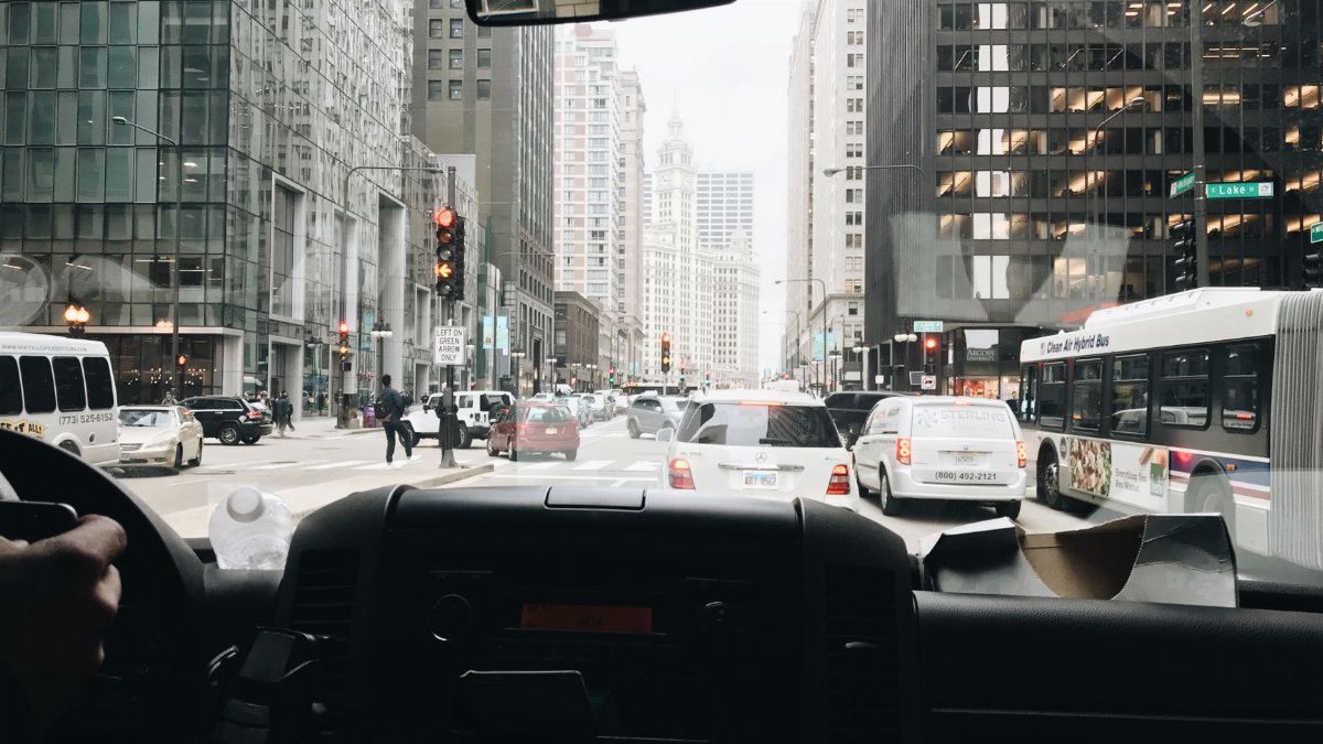 View of bustling Chicago street with traffic and skyscrapers from inside a vehicle.