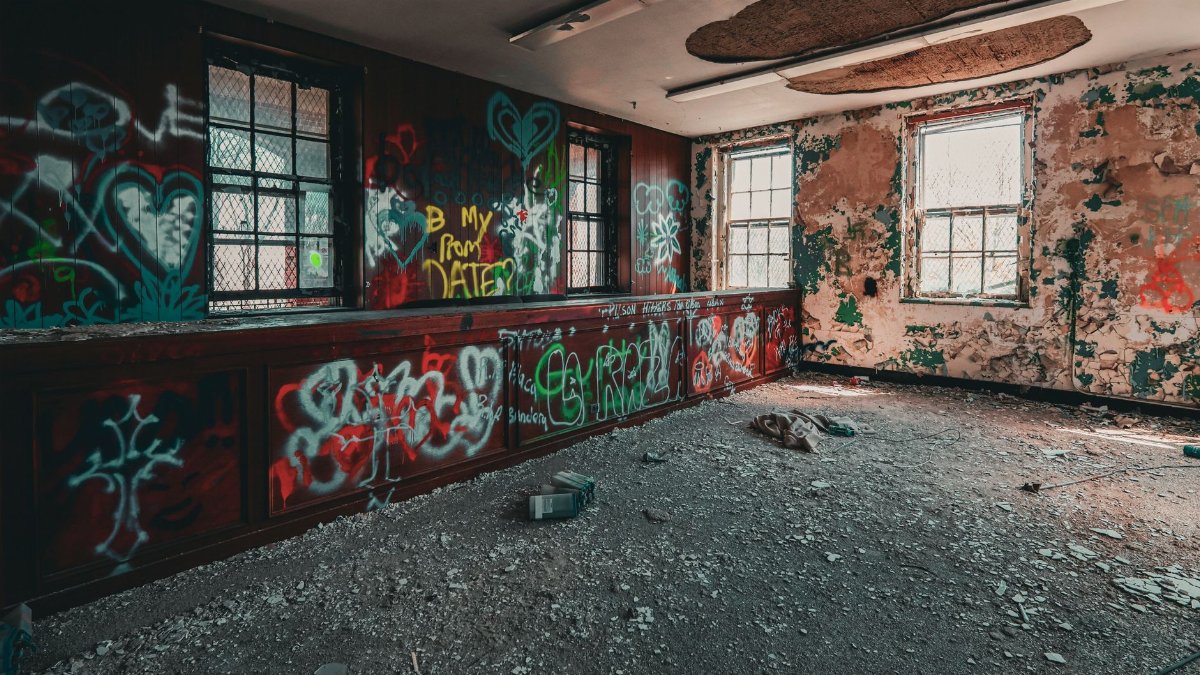 Explore an abandoned room filled with vibrant graffiti art and urban decay.