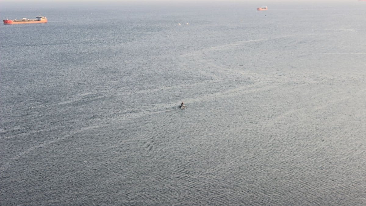 Calm seascape of ships floating on open water, captured from above.
