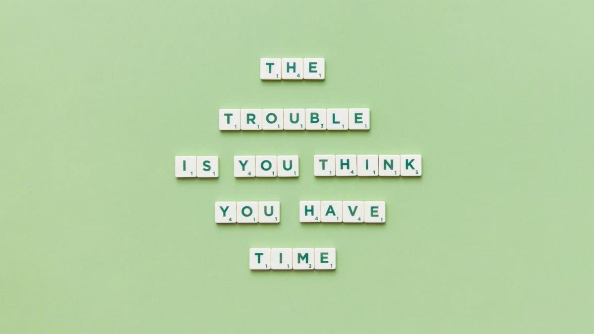 Scrabble tiles arranged to spell a motivational quote against a green background.