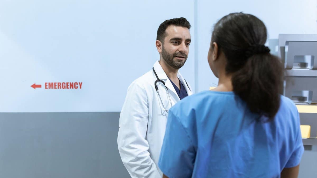 Doctors and nurses conversing near emergency room in a hospital setting.