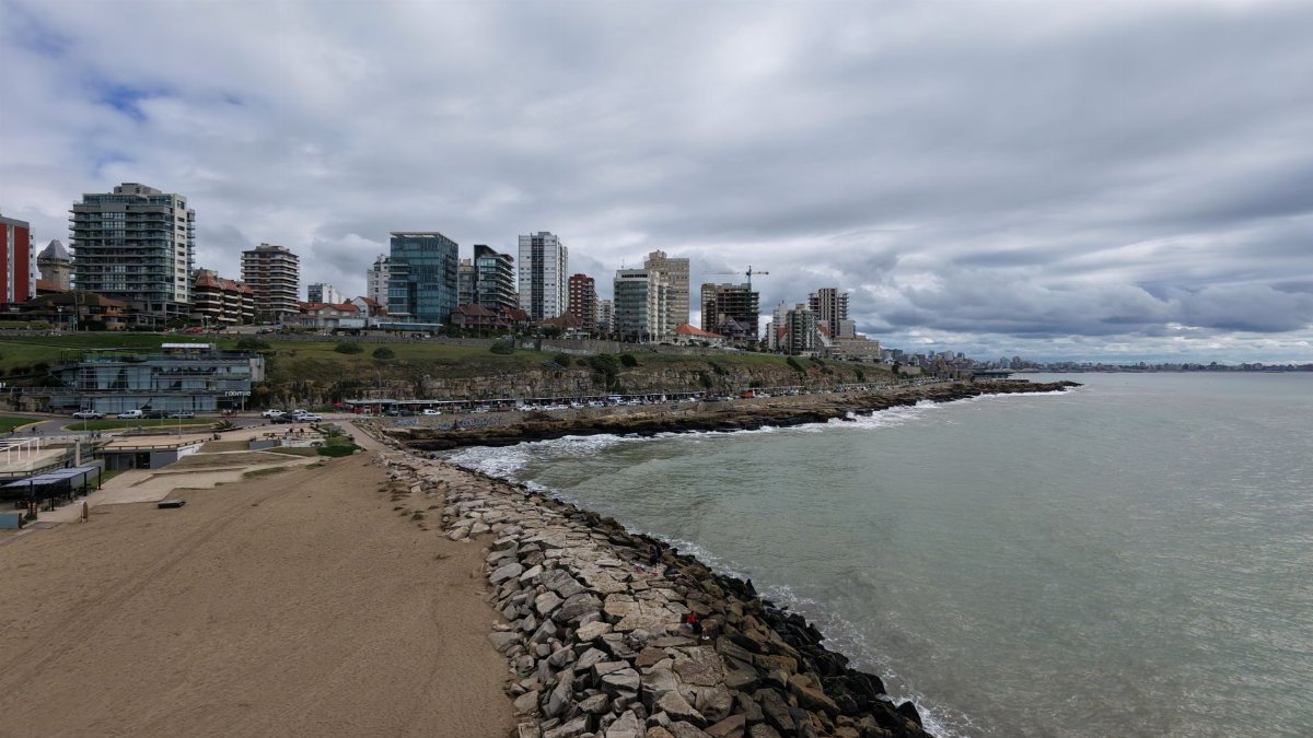 Dramatic city coastline featuring modern high-rise buildings facing a rocky shoreline.