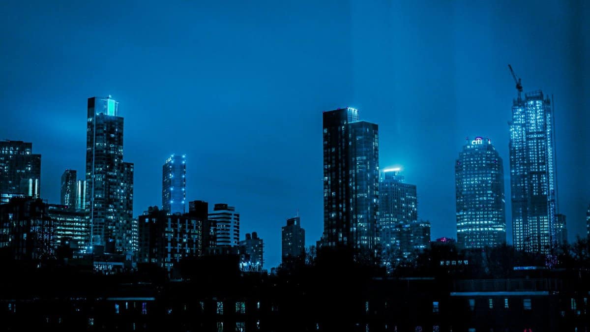 Explore the illuminated skyline with high-rise buildings reflecting city lights on a tranquil night.