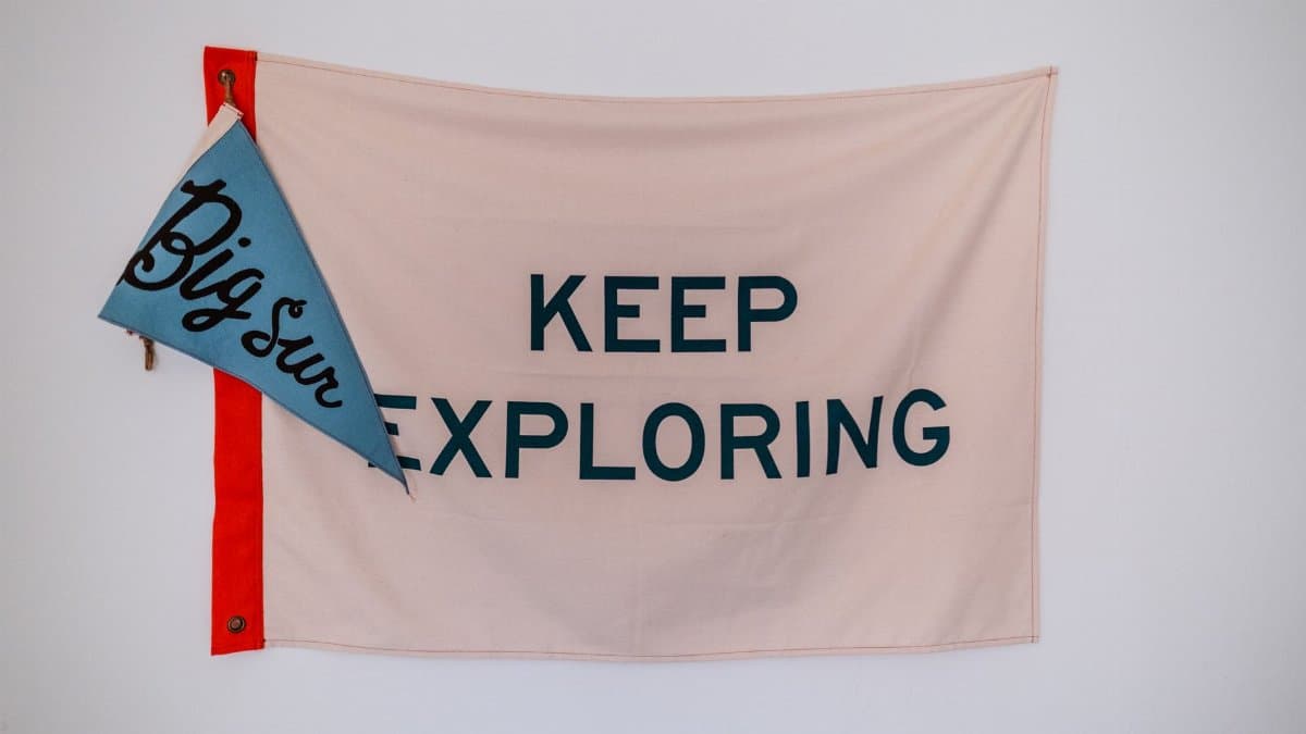 A motivational 'Keep Exploring' flag with 'Big Sur' pennant on a white background.
