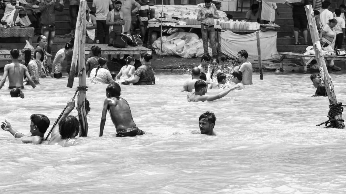 Monochrome photography capturing people swimming in a crowded public area.
