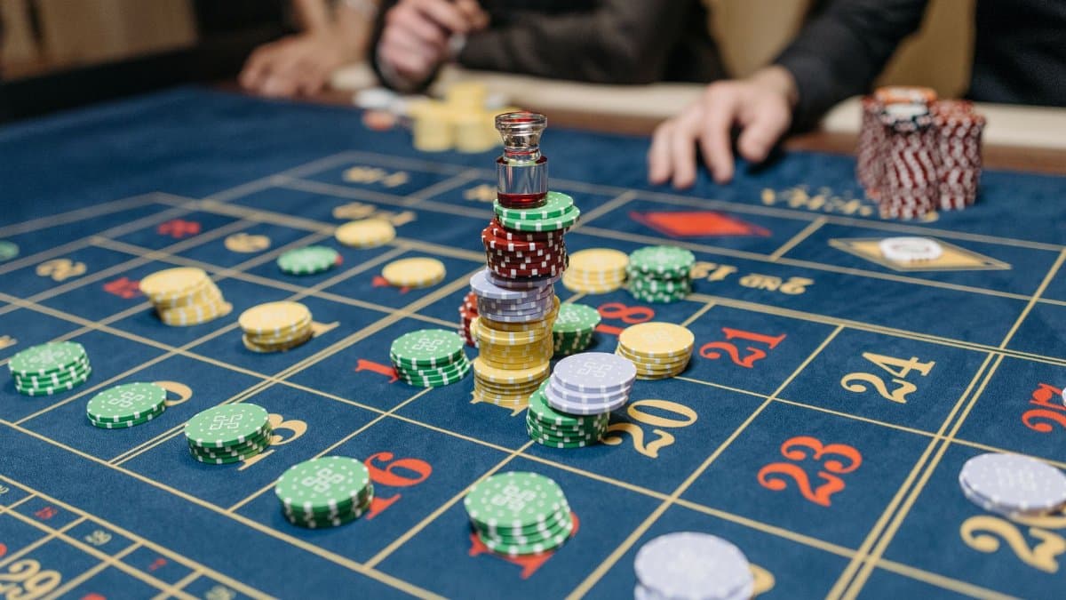 A casino table featuring stacked gaming chips and a roulette layout, suggesting gameplay.