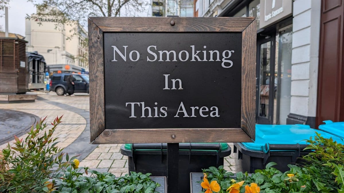 A wooden no smoking sign in a public area in London, enforcing a smoking ban.