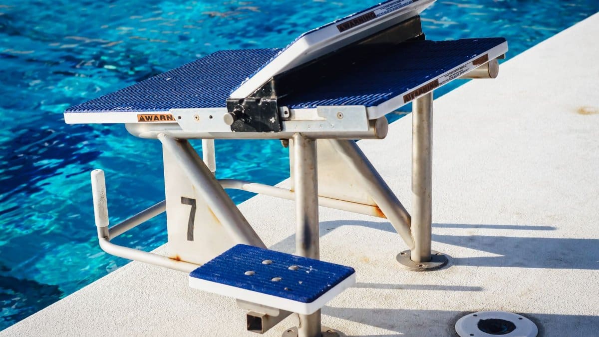 A close-up of a swimming pool starting block by the poolside, ready for competitors.