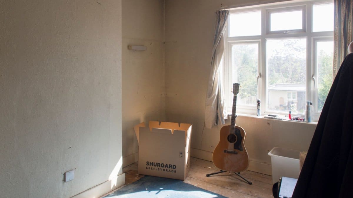 Sunlit room with guitar and moving box indicating home improvement work.