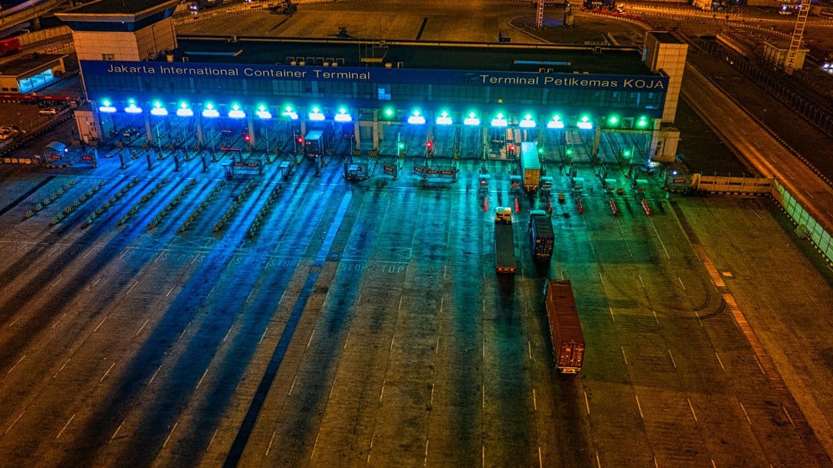 Illuminated aerial view of Jakarta International Container Terminal highlighting logistics activity at night.