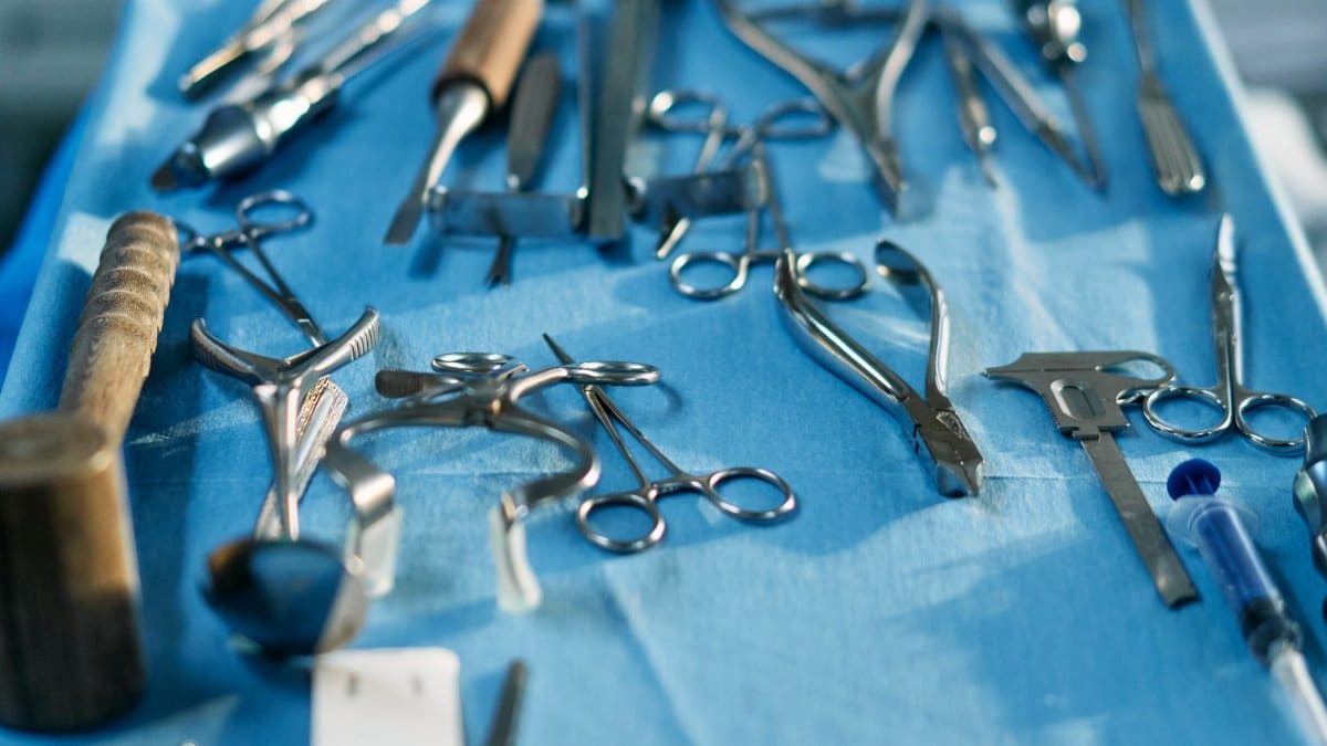 Close-up of various sterilized surgical tools laid out on a blue surface, ready for medical procedures.