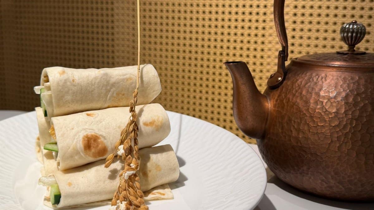 Aesthetic display of fresh tortilla wraps with a copper teapot, depicting a stylish dining setup.