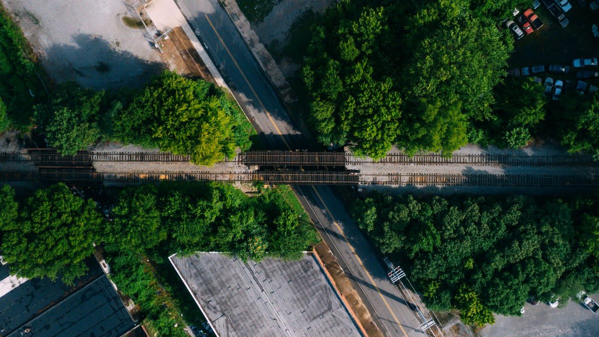 A scenic aerial view of railroad tracks intersecting roads surrounded by lush greenery in Chattanooga, TN.