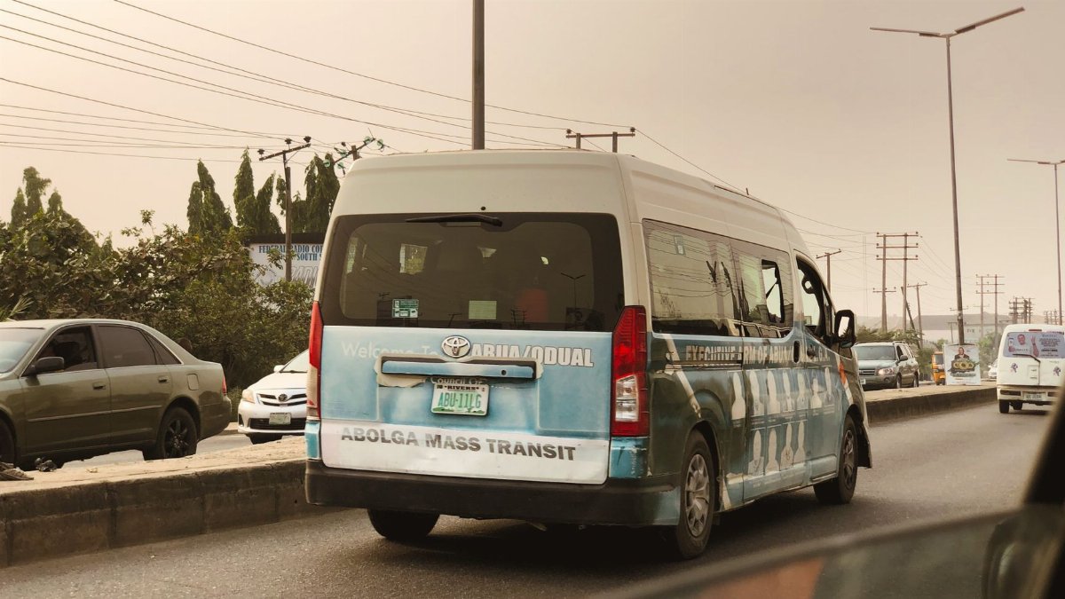 Traffic scene featuring mass transit van with city background