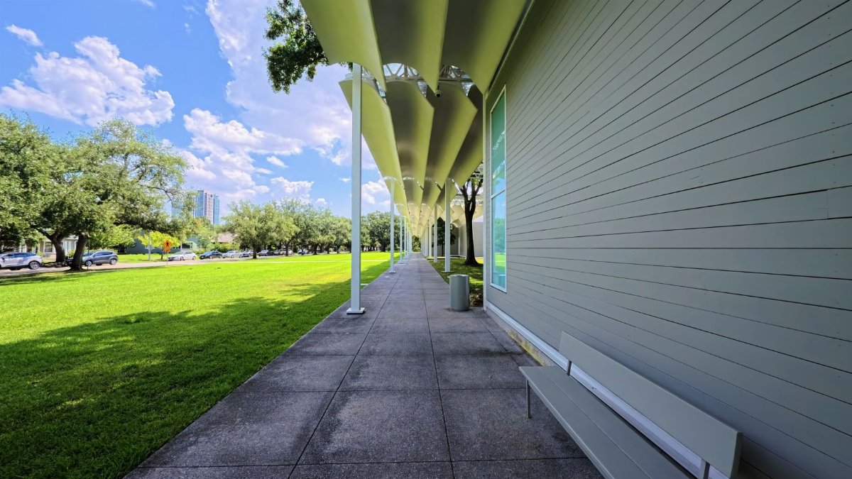 A sunny day view of a modern covered walkway at a park in Houston, TX.