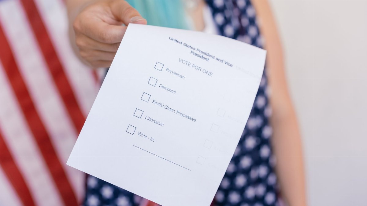 Close-up photo of a hand holding a US election voting ballot.