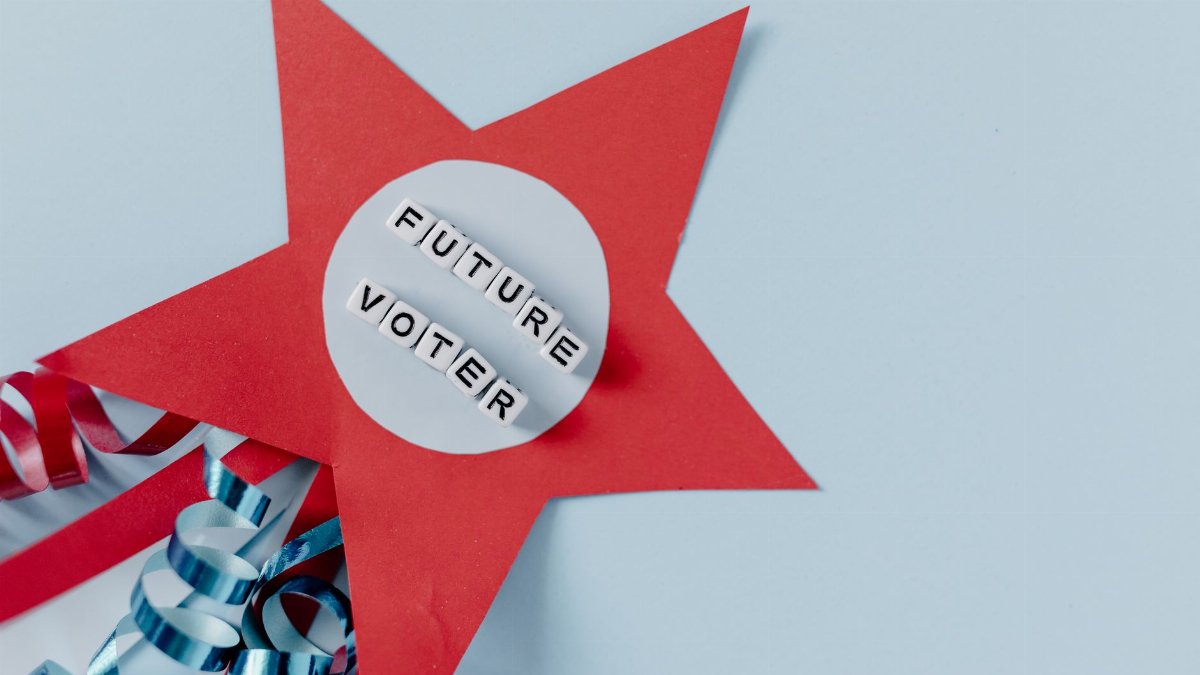 Red star decoration with 'Future Voter' text and blue ribbons on a light background.