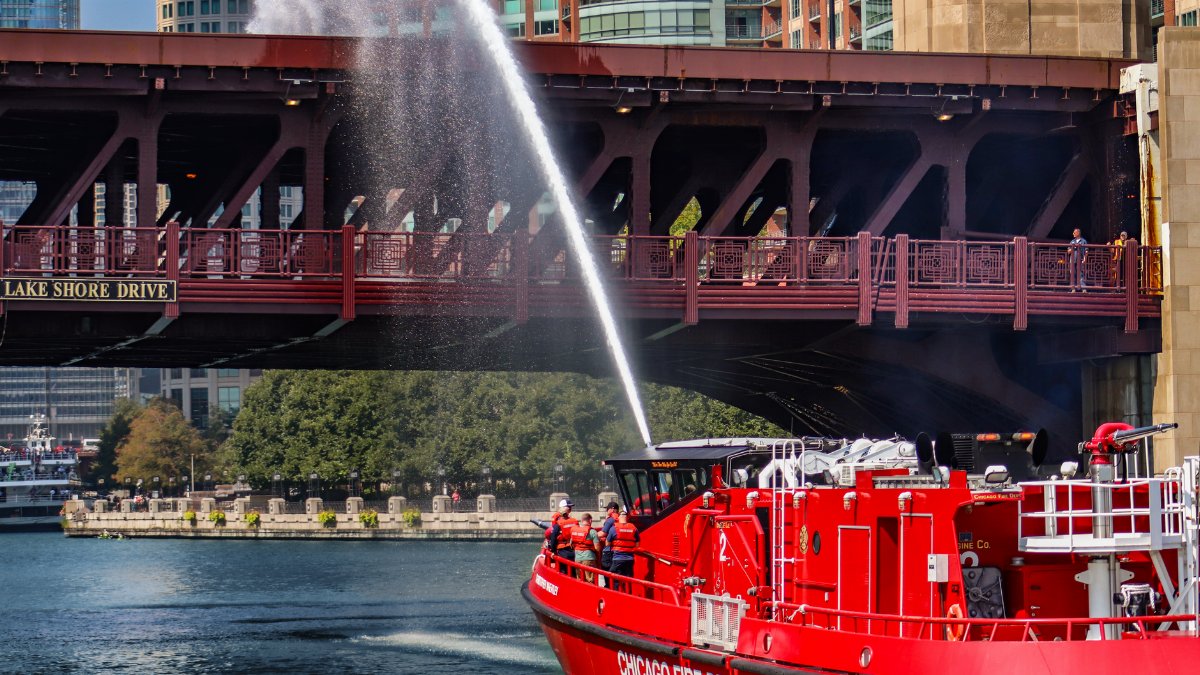 Chicago Fire Department boat spraying water near Lake Shore Drive Bridge on a sunny summer day.