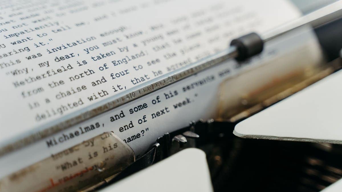 Close-up of a vintage typewriter typing manuscript pages in a classic style.