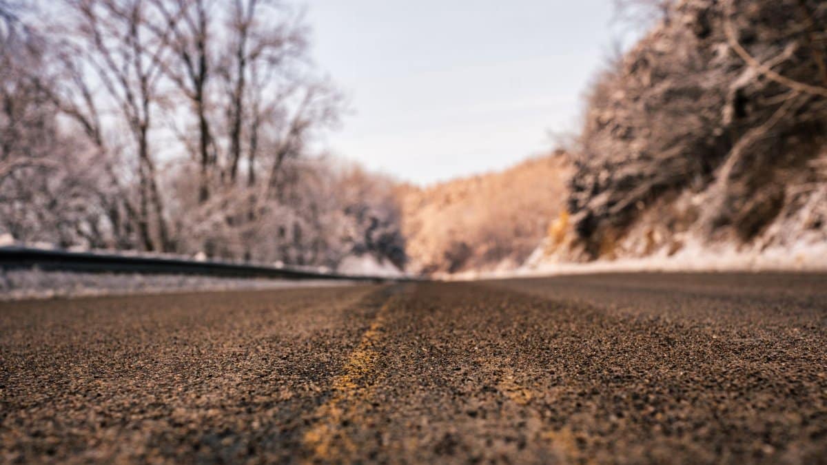 Captivating winter road scene in Weaver, MN, showcasing frosty trees and tarmac textures.