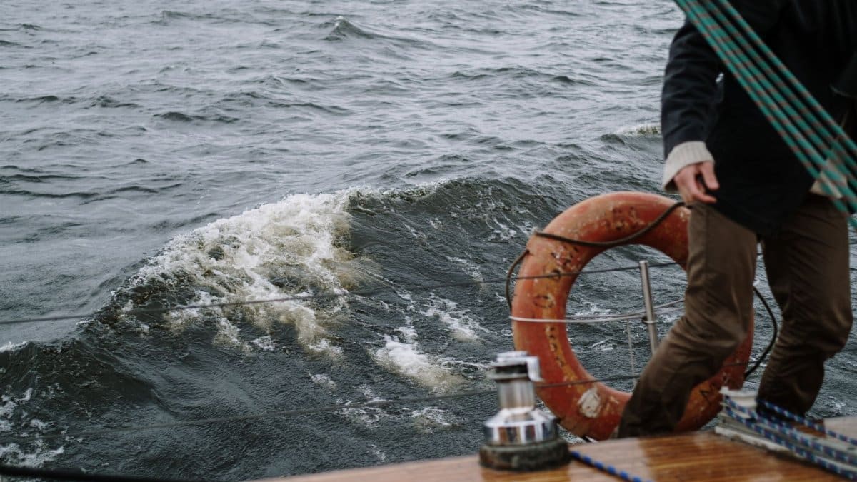 A close-up of a boat deck with an adventurous person navigating sea waves.