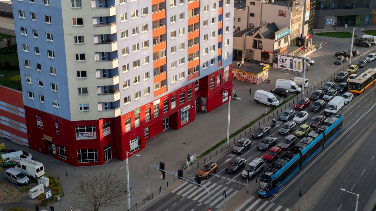 Aerial shot of street traffic and colorful building in Wrocław, Poland, during the day.
