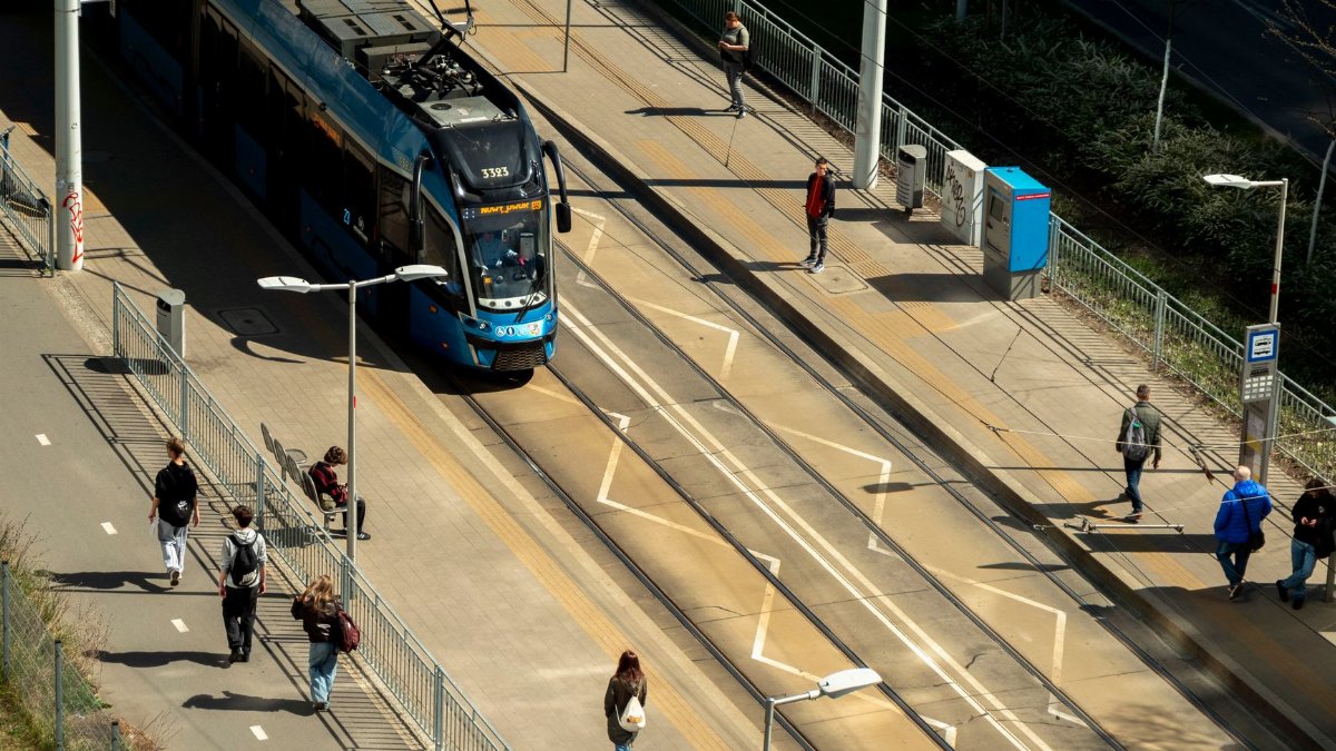 Aerial shot of a tram station in Wrocław, Poland, with people and a tram.
