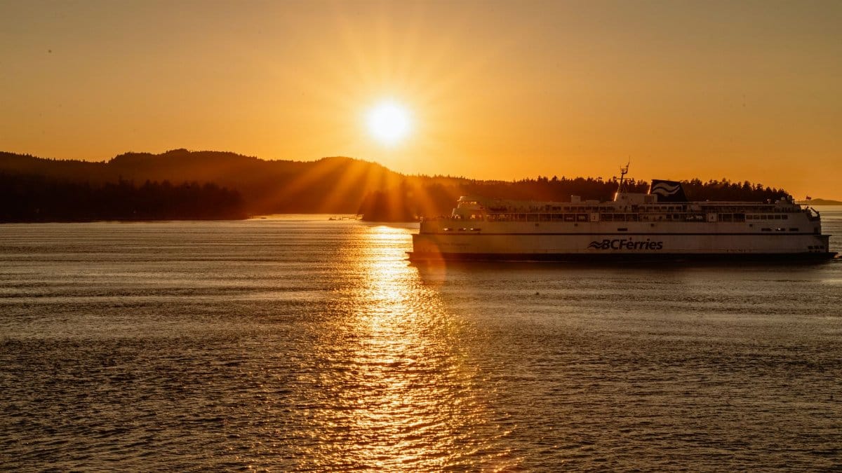 A BC Ferries ship sailing during a stunning golden sunset in BC, Canada.