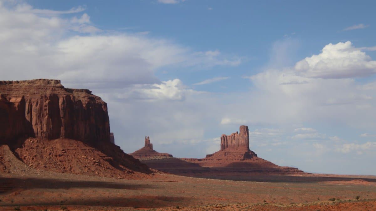 Breathtaking landscape of Monument Valley's iconic sandstone buttes under a vast blue sky.