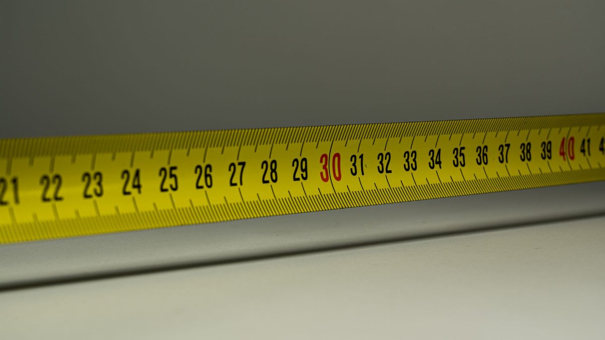 Close-up view of a yellow measuring tape with centimeter marks, emphasizing precision in measurement.
