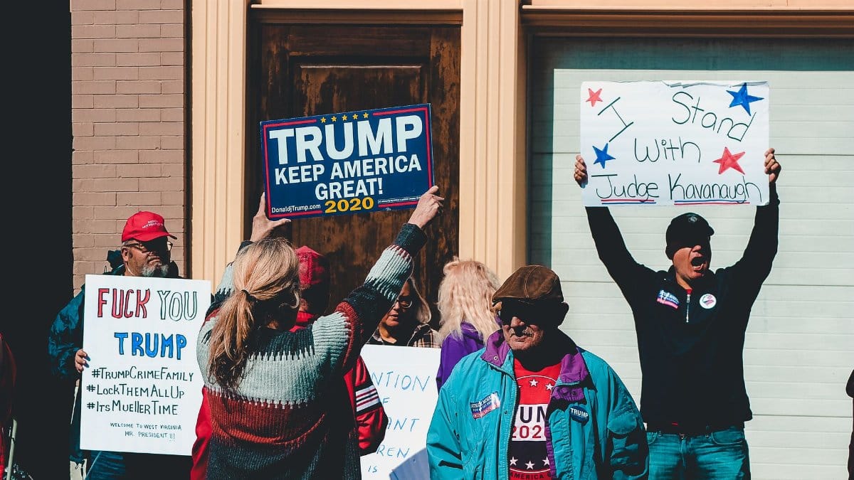 A group of people at a political rally in Wheeling, West Virginia, supporting different 2020 election campaigns.