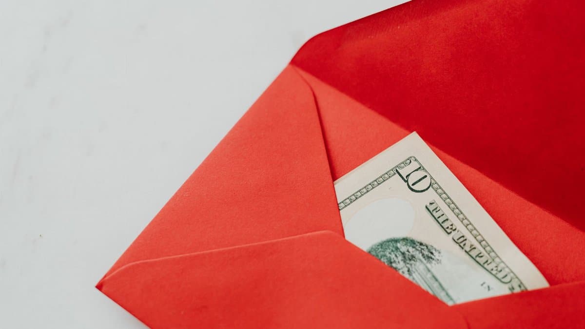 Close-up shot of cash in a red envelope, symbolizing gifting or New Year traditions.