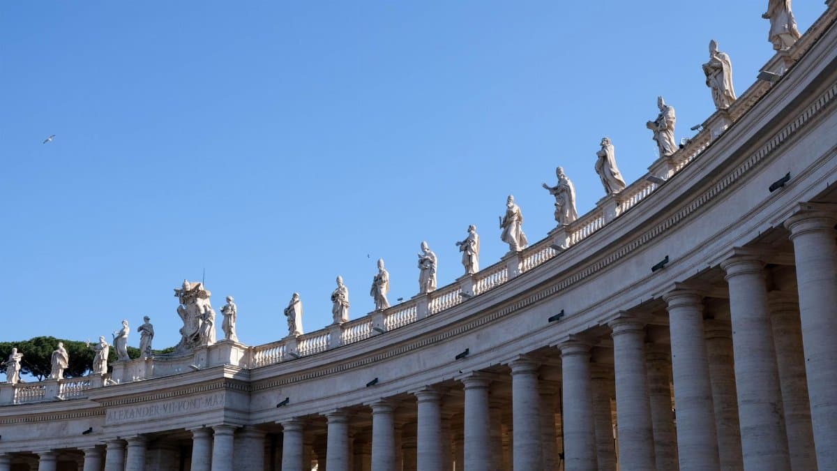 Elegant colonnade of St. Peter's Basilica in Vatican City showcasing historic sculptures.