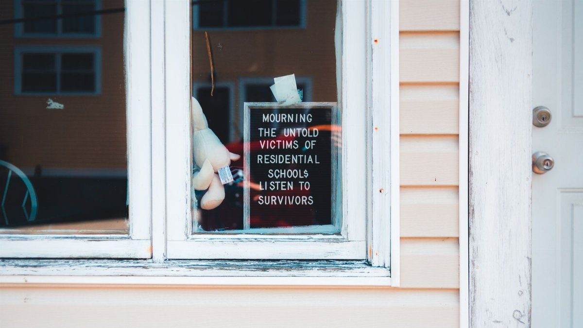 Sign in window mourns victims of residential schools. Support survivors.