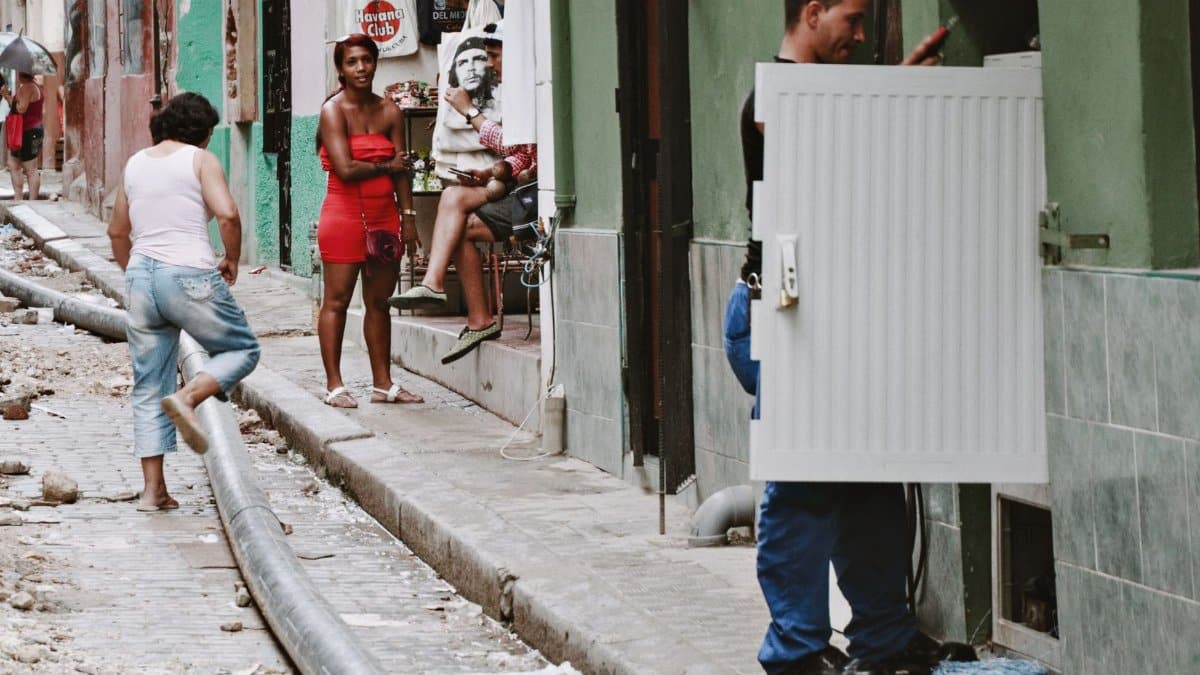 A lively street scene in Havana showcasing diverse people and ongoing street repairs.