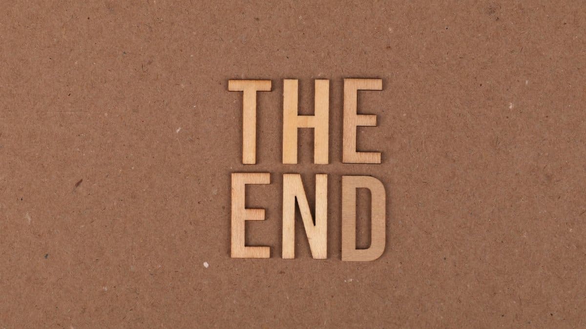 Wooden letters spelling 'The End' on a cardboard background.