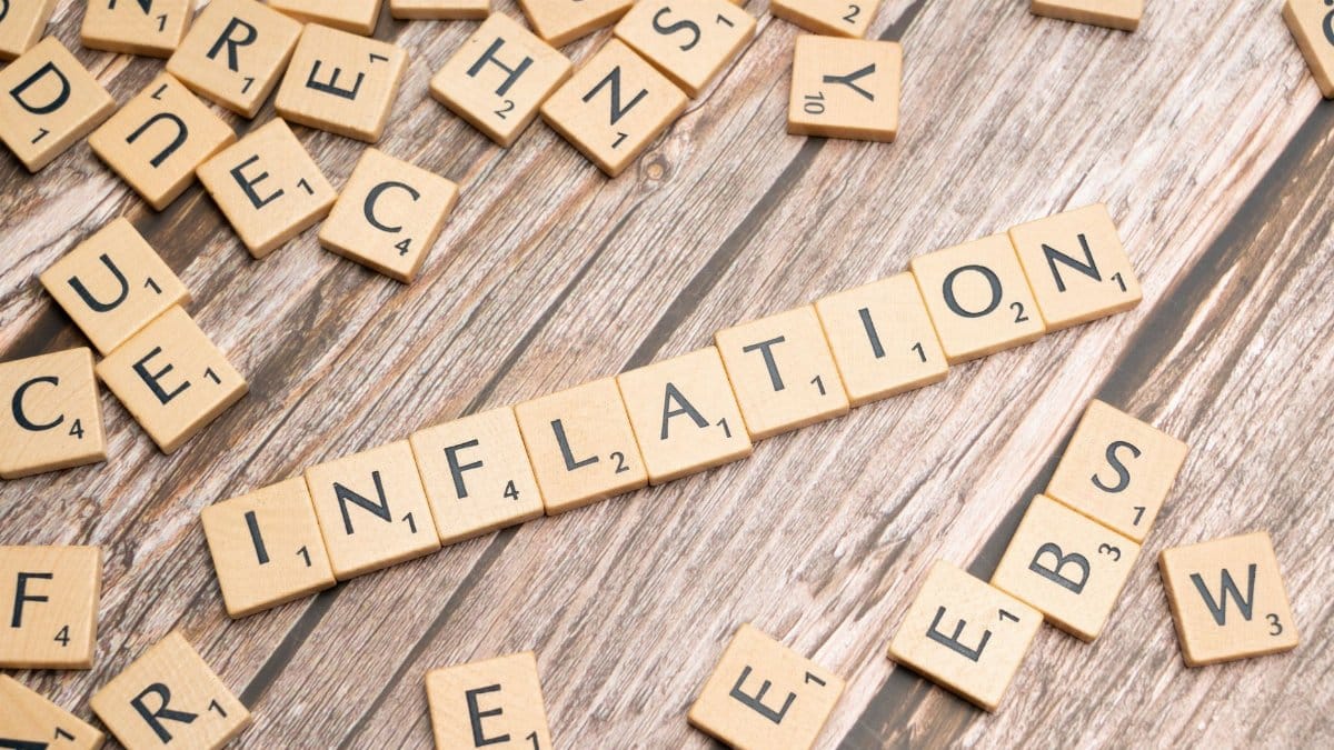 Wooden letter tiles forming the word 'inflation' on a rustic wooden surface, symbolizing economic themes.