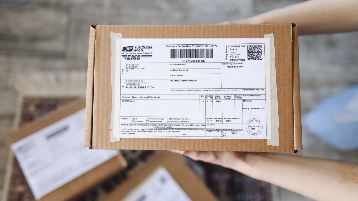 Top view of hands holding an express mail parcel with a customs declaration.