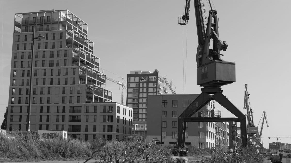 Black and white photo of urban construction showing cranes and modern buildings.