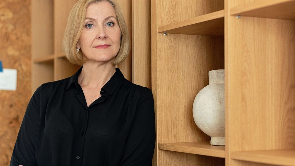 Confident businesswoman standing in an office setting, showcasing leadership.