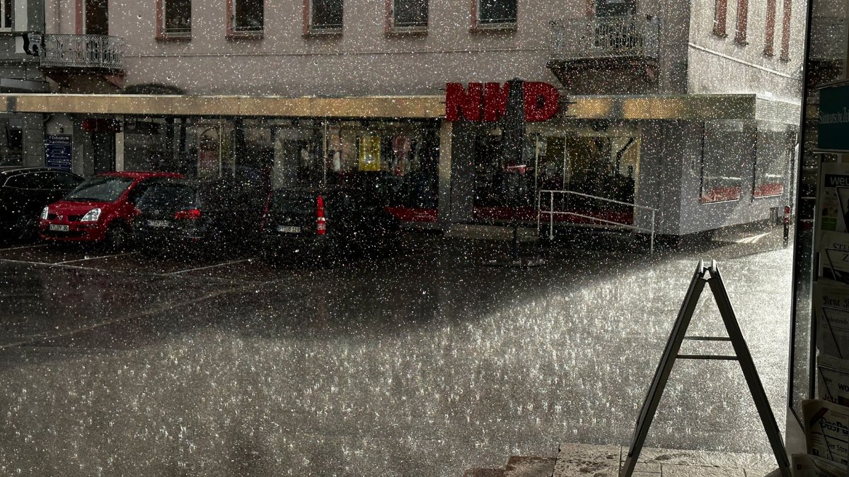 Rain falls on a city street in Bad Säckingen, Germany, showing urban life and weather.