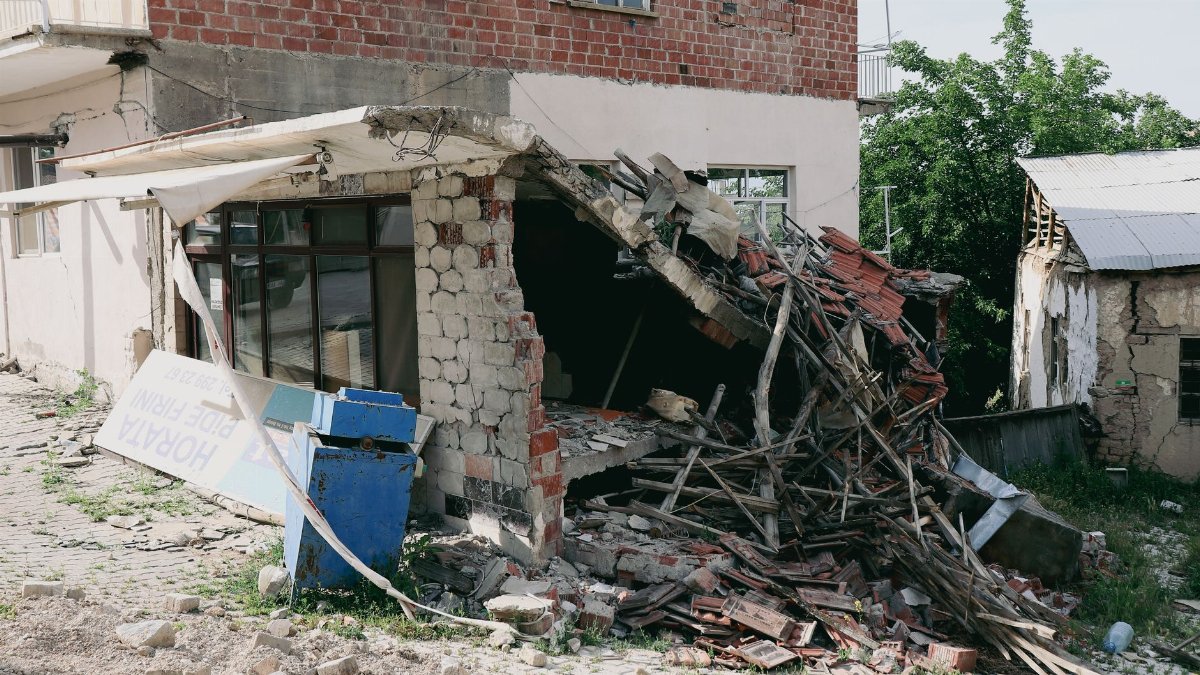A heavily damaged building exterior, showing structural collapse post-earthquake.