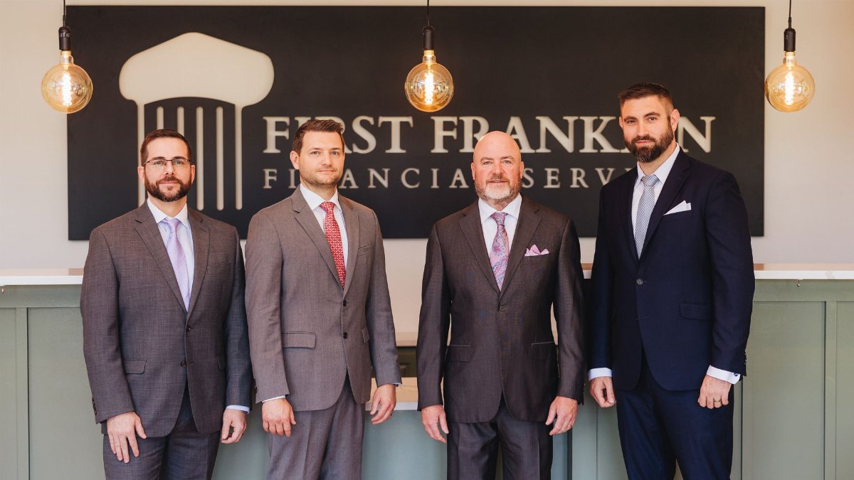 Group of businessmen posing in office setting at First Franklin Financial Services.