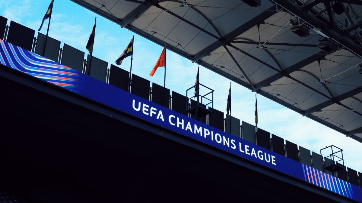 UEFA Champions League signage inside a stadium with flags and architectural details.