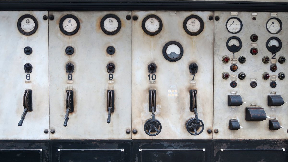 Old industrial control panel featuring vintage gauges and levers.