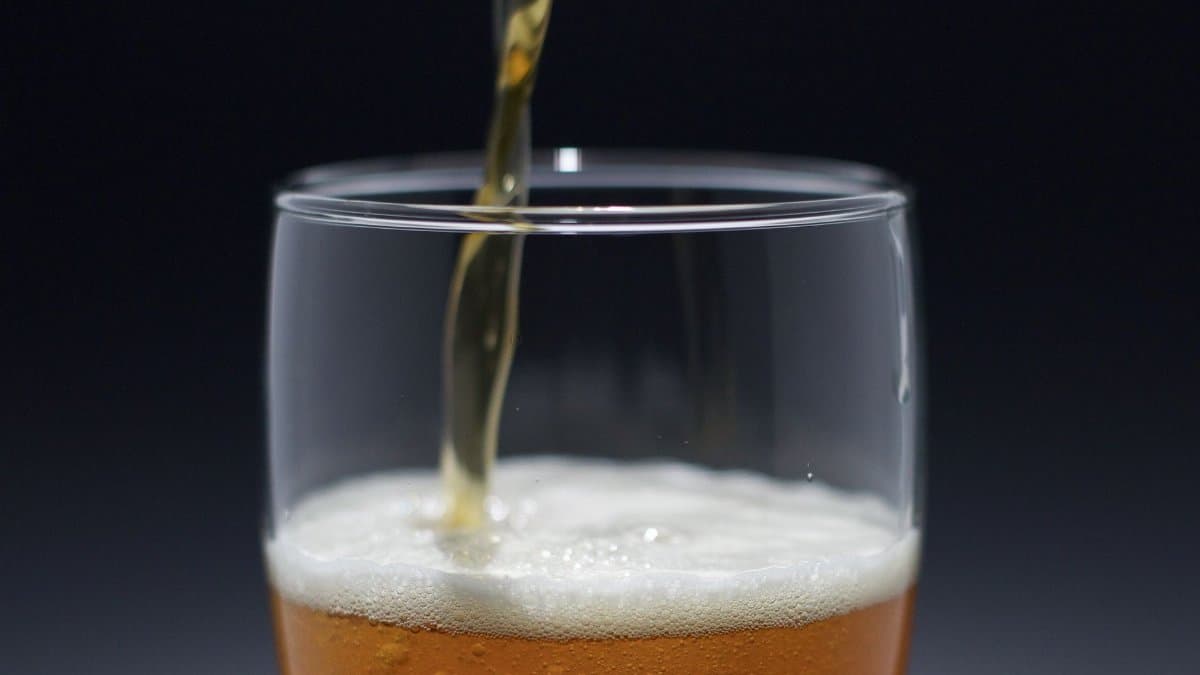 A refreshing beer pouring into a glass, capturing the foam and texture in detail.
