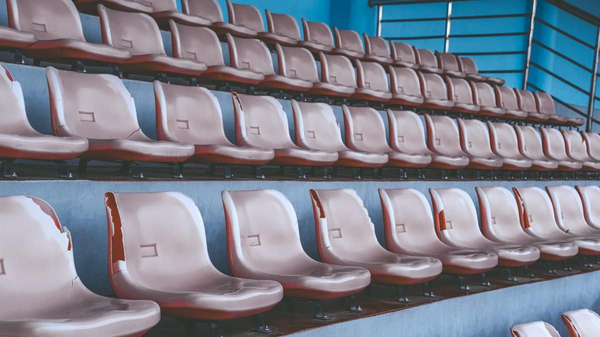 An array of empty plastic stadium seats in a geometric pattern, showcasing vibrant blue ambiance.