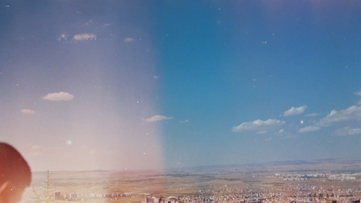 Aerial cityscape view under a clear blue sky with vintage film effect.